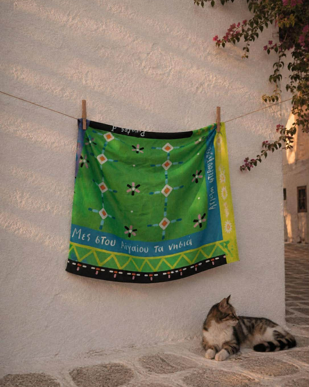 Το πράσινο μαντήλι με τα γεωμετρικά μοτίβα κρεμασμένο σε τοίχο στις Κυκλάδες
