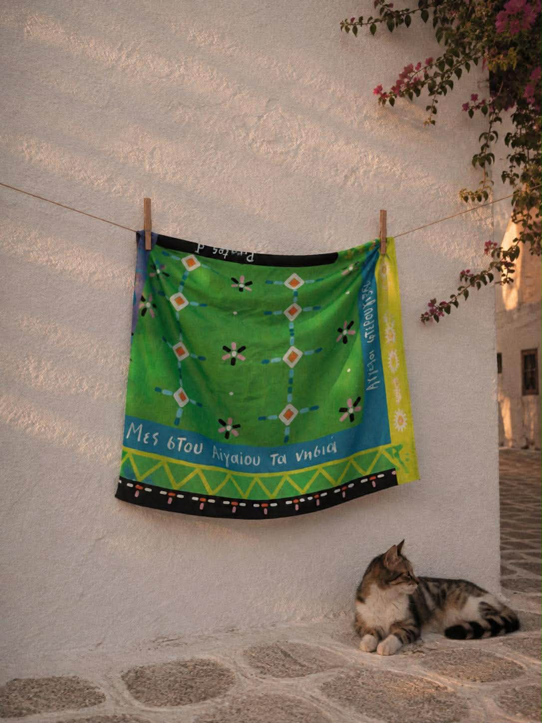 Το πράσινο μαντήλι με τα γεωμετρικά μοτίβα κρεμασμένο σε τοίχο στις Κυκλάδες