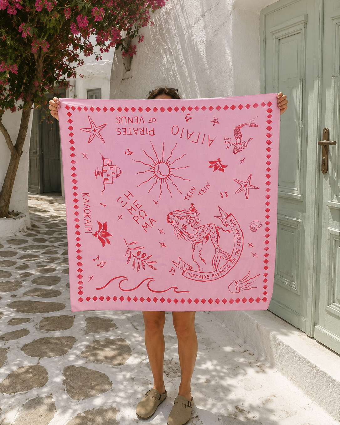Κοπελα στην Παρο κρατα σατεν μαντηλι ροζ με κοκκινο γραμμικο τυπωμα με γοργονες και αλλα ελληνικα στοιχεια.