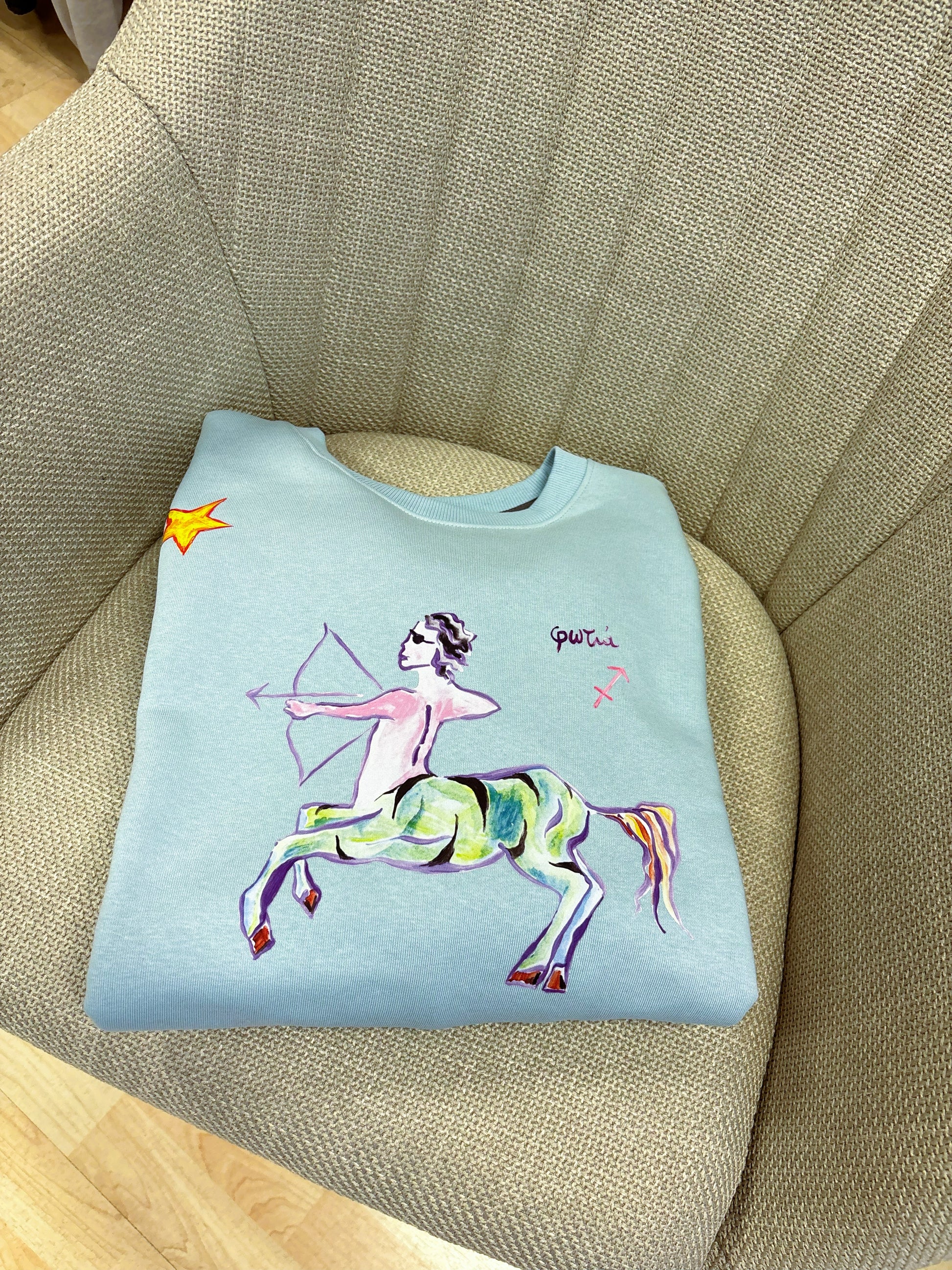 100% βαμβακερό φούτερ ελληνικής ραφής με πολύχρωμα τυπώματα μπροστά, πίσω και στα δύο μανίκια με θέμα το ζώδιο του Τοξότη.