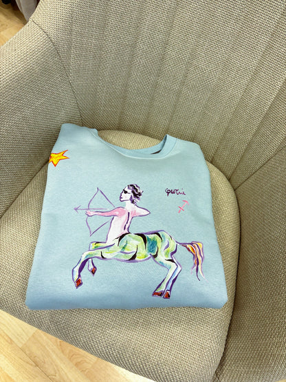 100% βαμβακερό φούτερ ελληνικής ραφής με πολύχρωμα τυπώματα μπροστά, πίσω και στα δύο μανίκια με θέμα το ζώδιο του Τοξότη.